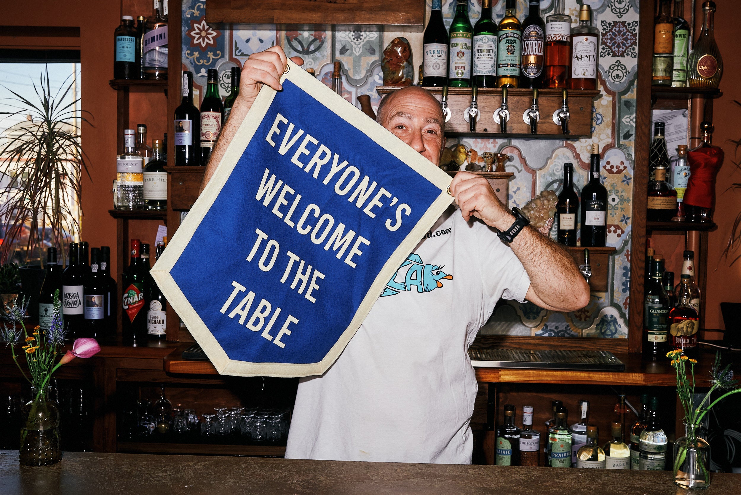 Joshua with "everyone's welcome to the table" flag