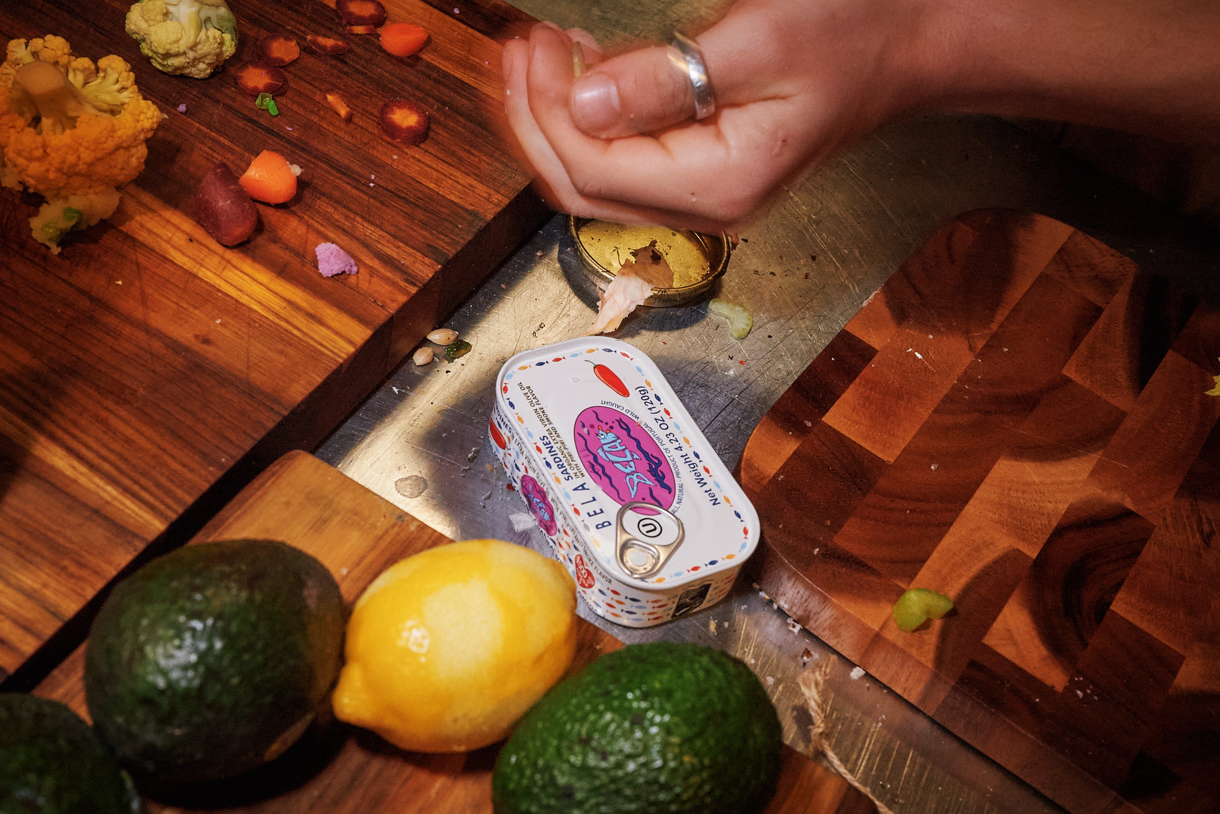 BELA tin next to cutting boards with limes and lemons